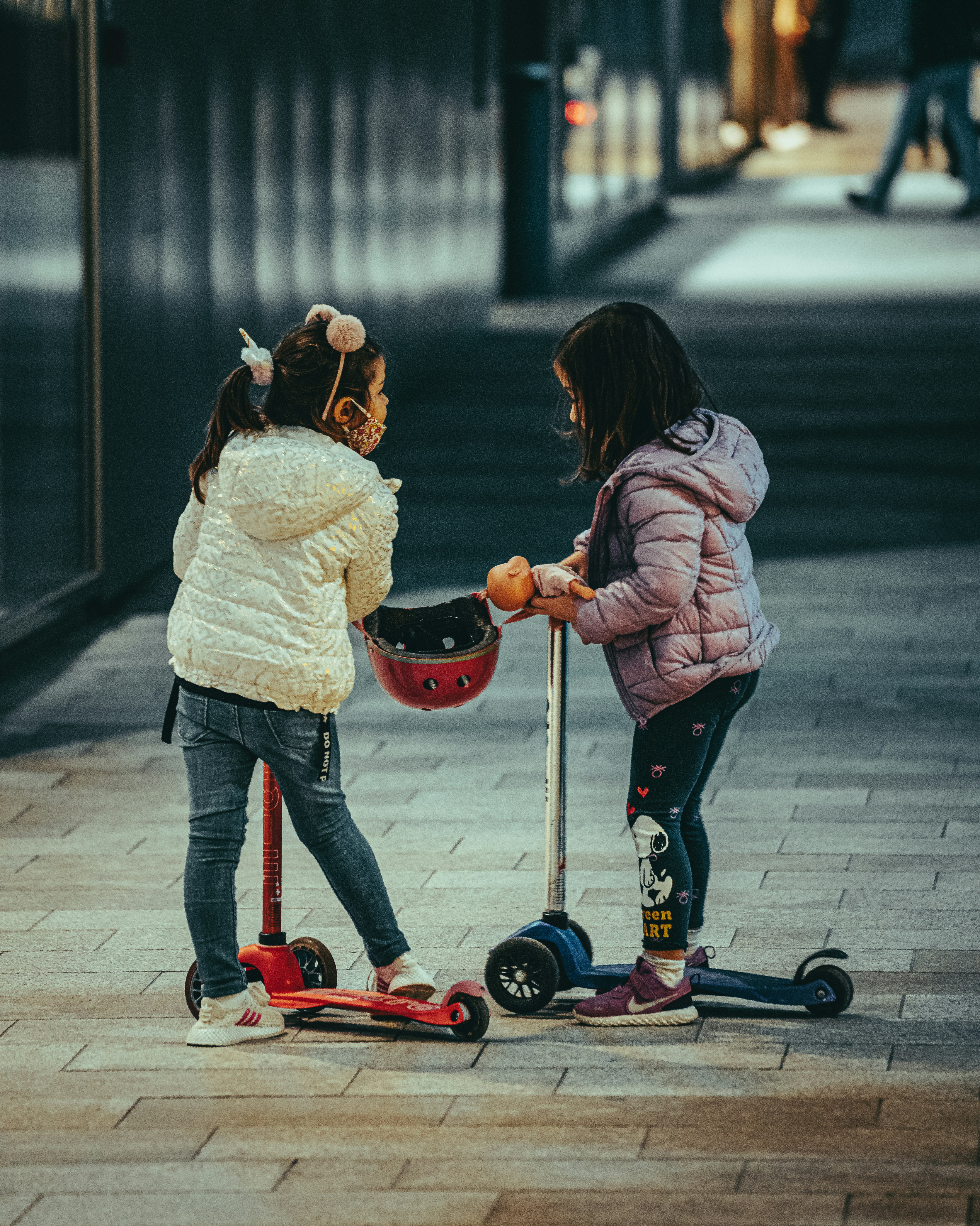 girl in white jacket riding red kick scooter during daytime